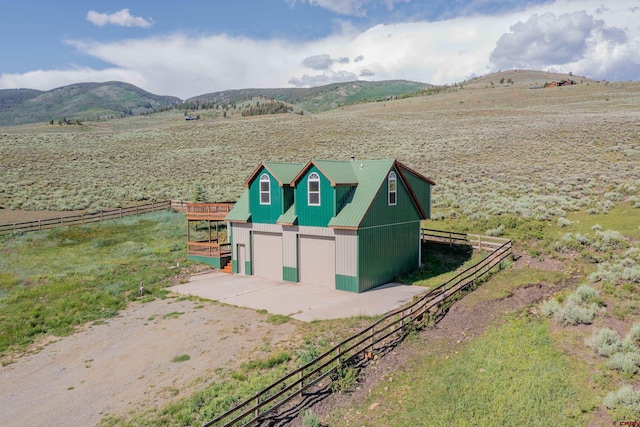 exterior space featuring an outdoor structure, a mountain view, a rural view, and a garage