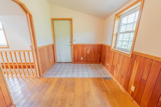 empty room with light tile floors and lofted ceiling