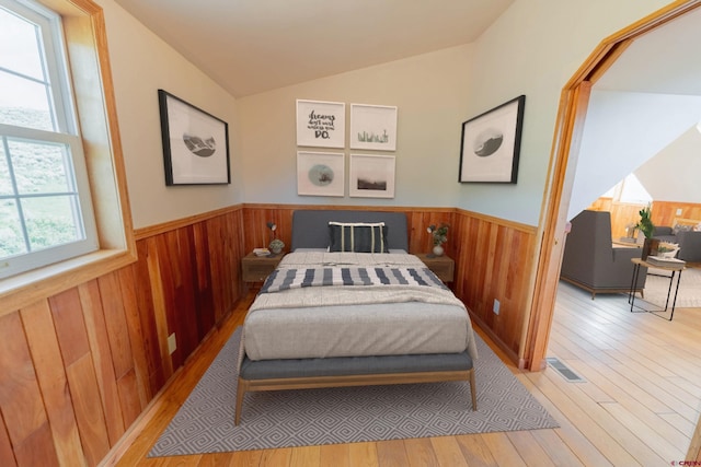 bedroom featuring lofted ceiling and light wood-type flooring