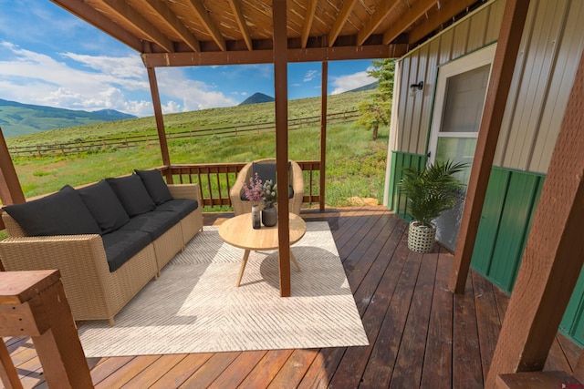 deck with a mountain view, a rural view, and an outdoor living space