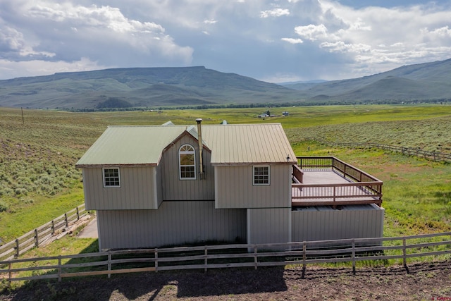 exterior space with a deck with mountain view and a rural view