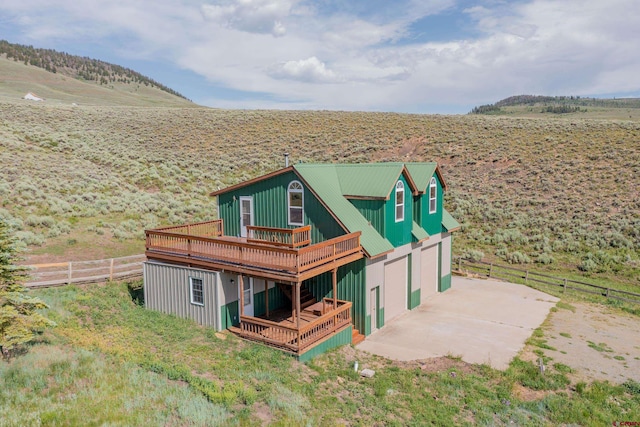 exterior space featuring a wooden deck, a garage, and a rural view