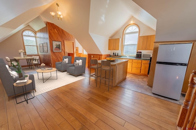 kitchen featuring an inviting chandelier, light hardwood / wood-style flooring, appliances with stainless steel finishes, sink, and a breakfast bar