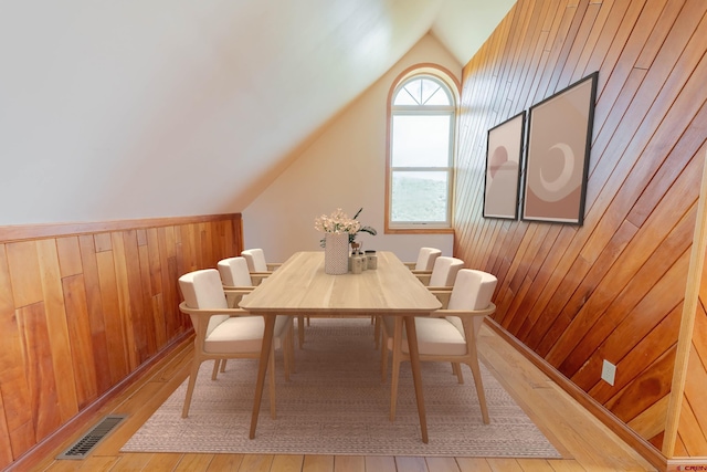 dining room with vaulted ceiling and wood-type flooring