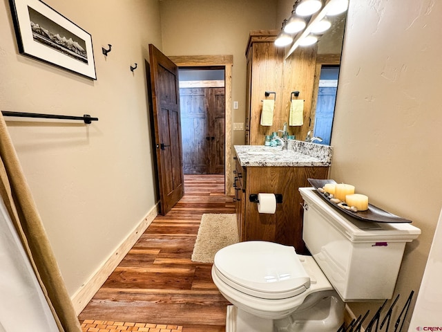 bathroom with wood-type flooring, toilet, and vanity