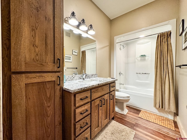 full bathroom with shower / tub combo, hardwood / wood-style floors, toilet, and vanity with extensive cabinet space