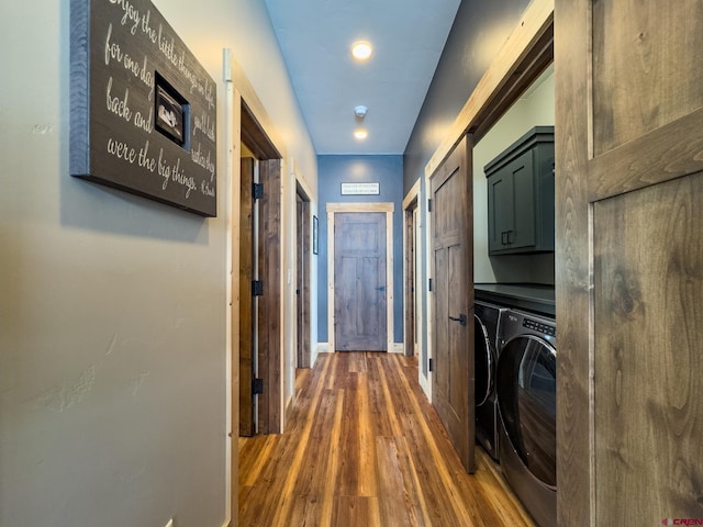 laundry room with cabinets, dark wood-type flooring, and washing machine and clothes dryer