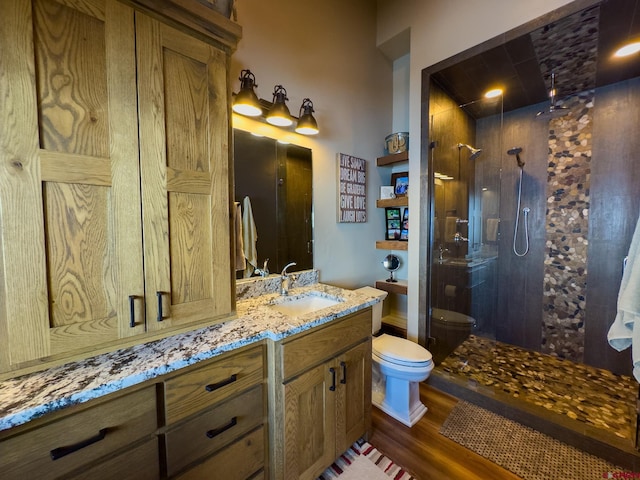 bathroom with wood-type flooring, an enclosed shower, toilet, and large vanity