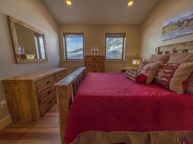 bedroom featuring hardwood / wood-style flooring and lofted ceiling