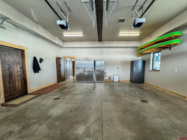 garage with a garage door opener and stainless steel fridge