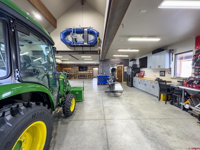 garage featuring black fridge and a workshop area