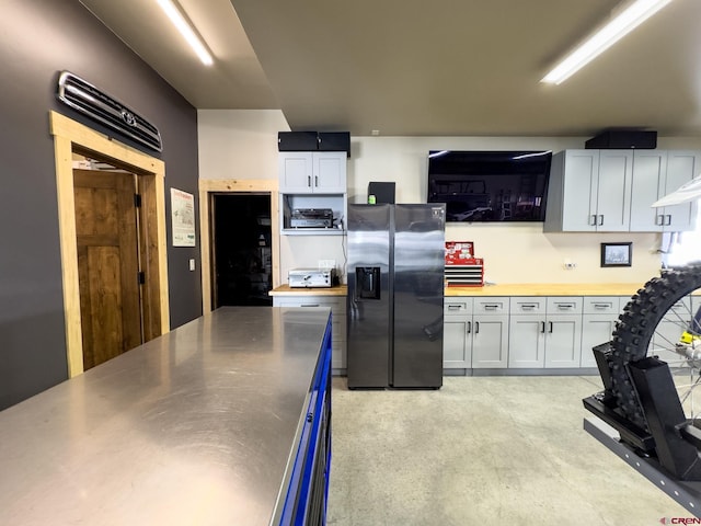 kitchen featuring wooden counters, white cabinetry, and stainless steel refrigerator with ice dispenser