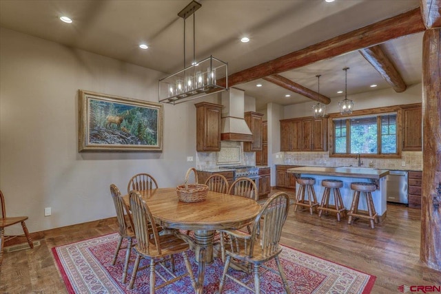 dining space featuring beamed ceiling, sink, and dark hardwood / wood-style floors