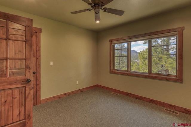 carpeted spare room with ceiling fan