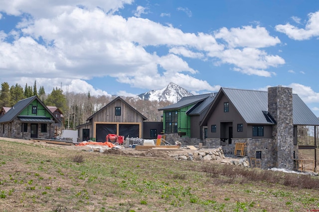 back of house featuring a mountain view and an outbuilding