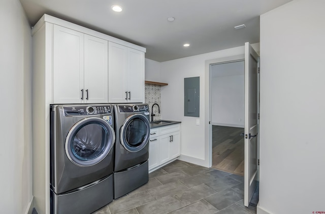 laundry room with washer and clothes dryer, cabinets, sink, and electric panel