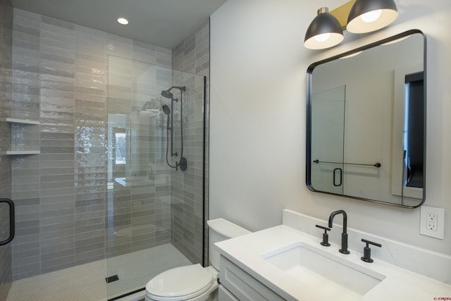 bathroom featuring vanity, toilet, and a shower with door