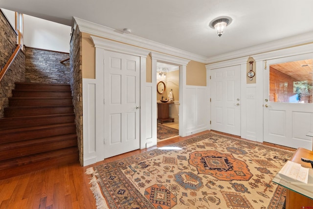 entryway featuring wood-type flooring and crown molding