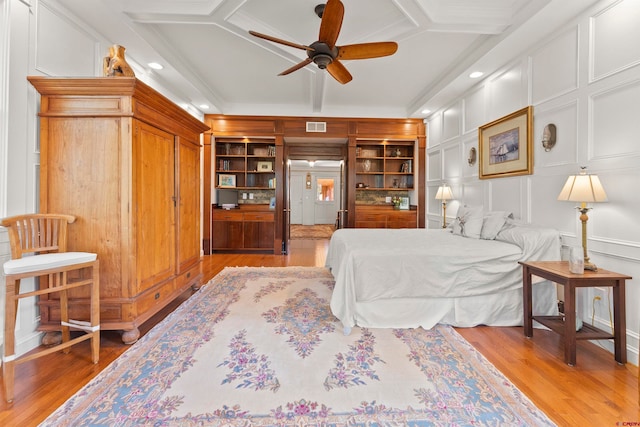 bedroom with light hardwood / wood-style floors, coffered ceiling, and ceiling fan