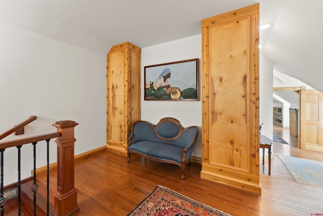 living area with vaulted ceiling and wood-type flooring