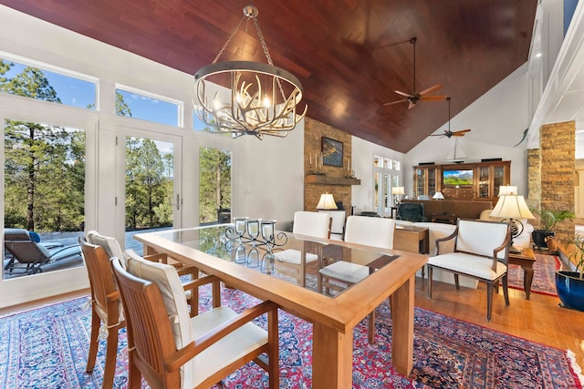 dining room with high vaulted ceiling, ceiling fan with notable chandelier, hardwood / wood-style floors, and wood ceiling