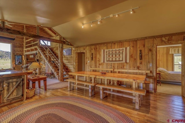 101 Spirit Path Ct, Pagosa Springs, CO 81147 - dining space featuring wooden walls, stairway, wood finished floors, rail lighting, and lofted ceiling