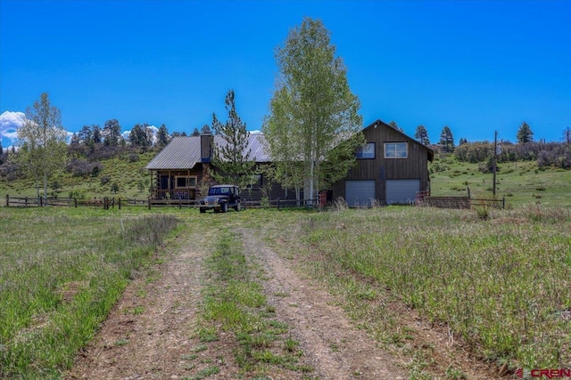 101 Spirit Path Ct, Pagosa Springs, CO 81147 - view of front of home with driveway, a garage, metal roof, log siding, and a view of countryside