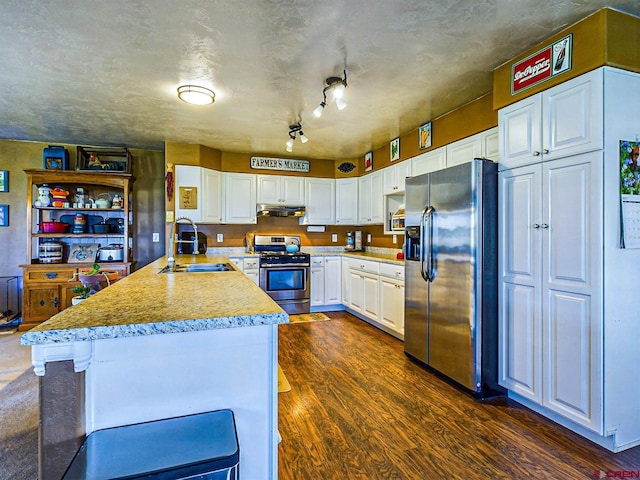 kitchen with sink, a breakfast bar area, stainless steel appliances, white cabinets, and dark hardwood / wood-style flooring