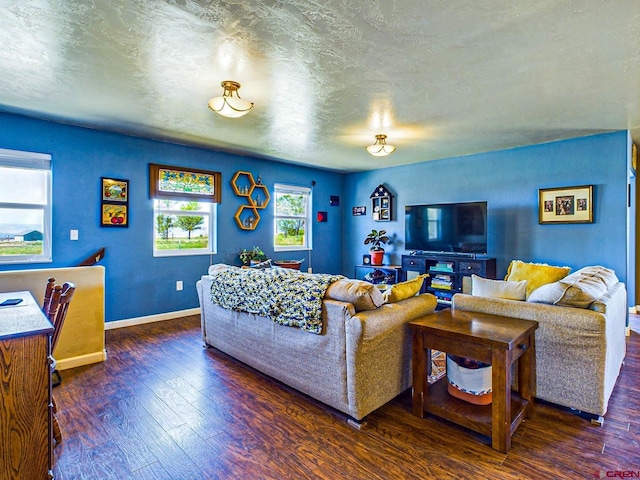 living room with a textured ceiling and dark hardwood / wood-style flooring