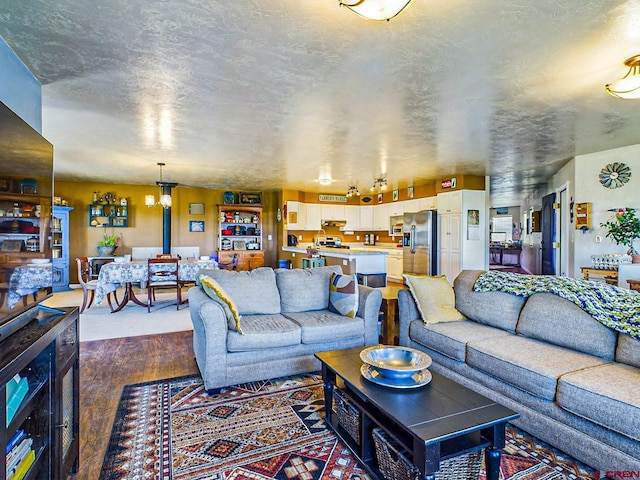 living room with dark hardwood / wood-style flooring and a textured ceiling