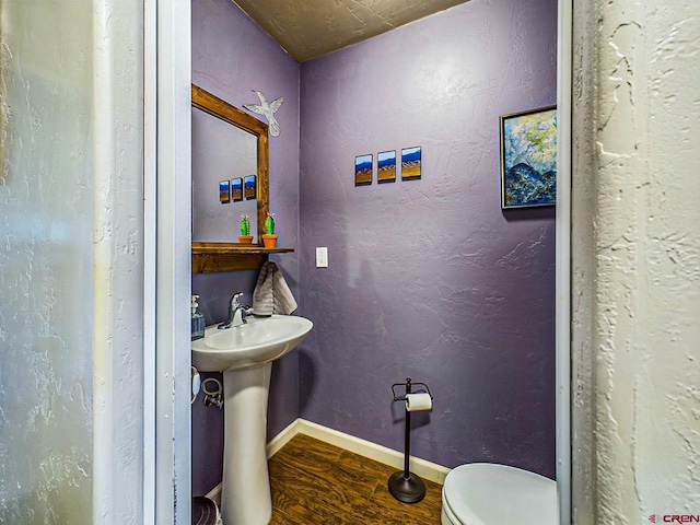 bathroom featuring toilet, sink, and hardwood / wood-style flooring