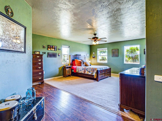 bedroom with ceiling fan, a textured ceiling, and hardwood / wood-style floors