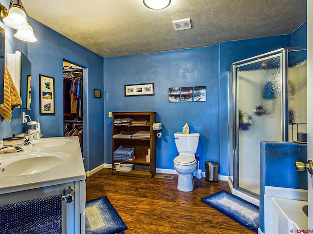 full bathroom featuring hardwood / wood-style flooring, a textured ceiling, toilet, and shower with separate bathtub