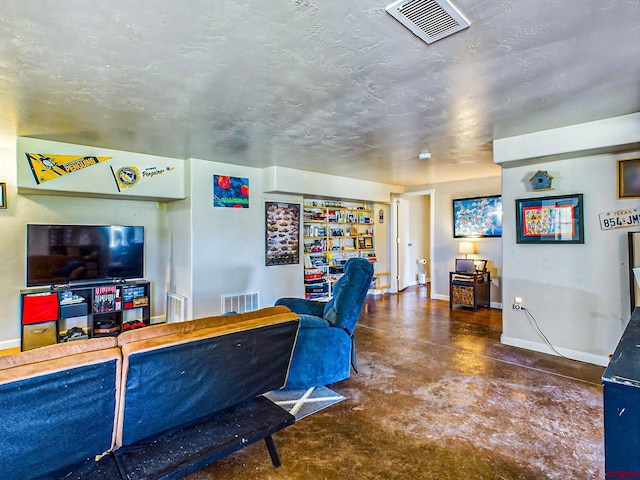 living room featuring a textured ceiling and concrete flooring