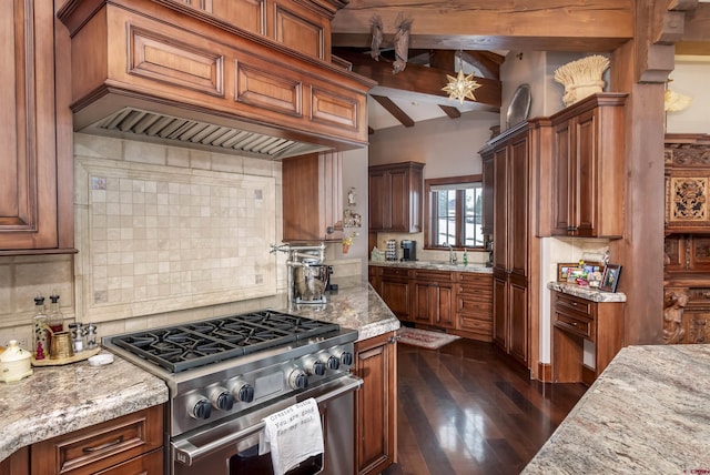 kitchen with high end range, premium range hood, dark hardwood / wood-style floors, light stone countertops, and beamed ceiling