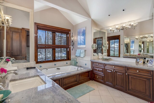 bathroom with a bath, a healthy amount of sunlight, tile patterned floors, and lofted ceiling