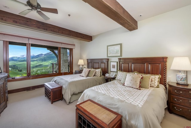 bedroom with beamed ceiling, ceiling fan, and light carpet