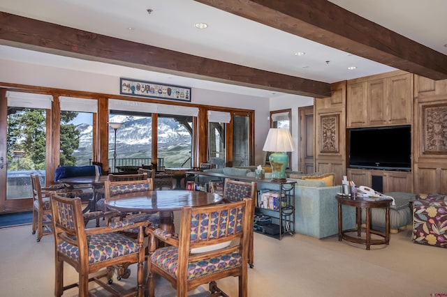 dining space with light carpet and beam ceiling