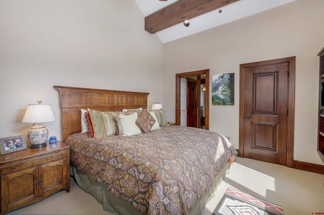 bedroom featuring light carpet and vaulted ceiling with beams