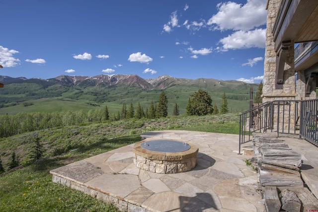 view of patio / terrace with a mountain view, a rural view, and a fire pit