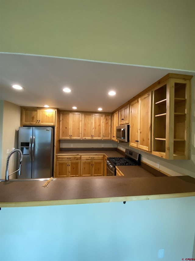 kitchen featuring light brown cabinets, kitchen peninsula, sink, and appliances with stainless steel finishes