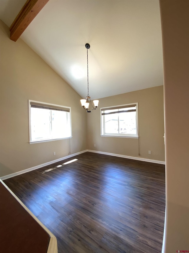 empty room featuring lofted ceiling with beams, dark hardwood / wood-style flooring, a wealth of natural light, and an inviting chandelier