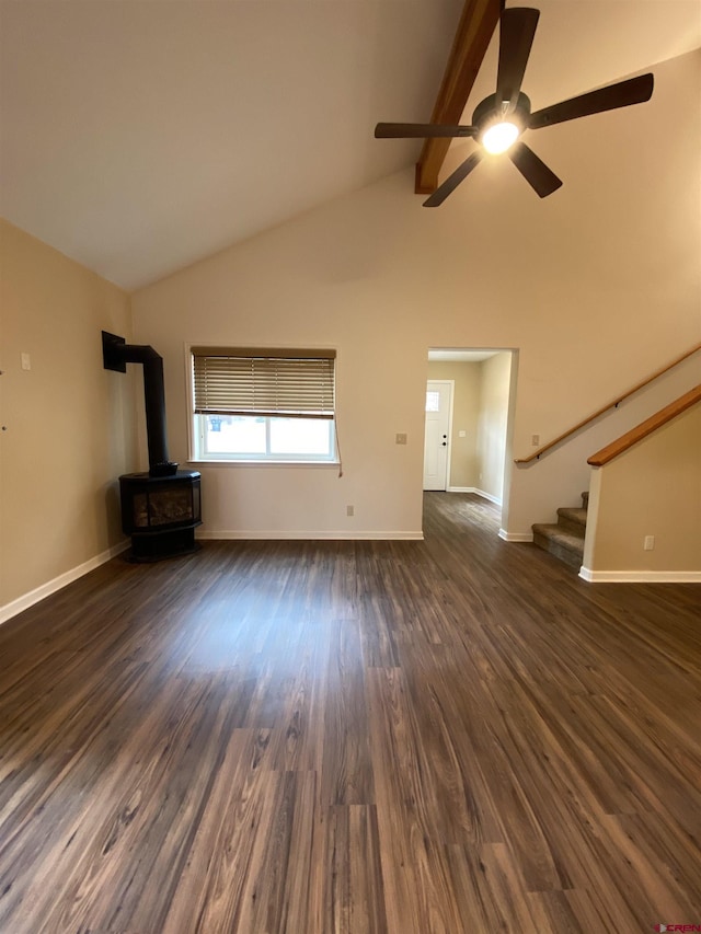 unfurnished living room featuring lofted ceiling with beams, a wood stove, ceiling fan, and dark wood-type flooring