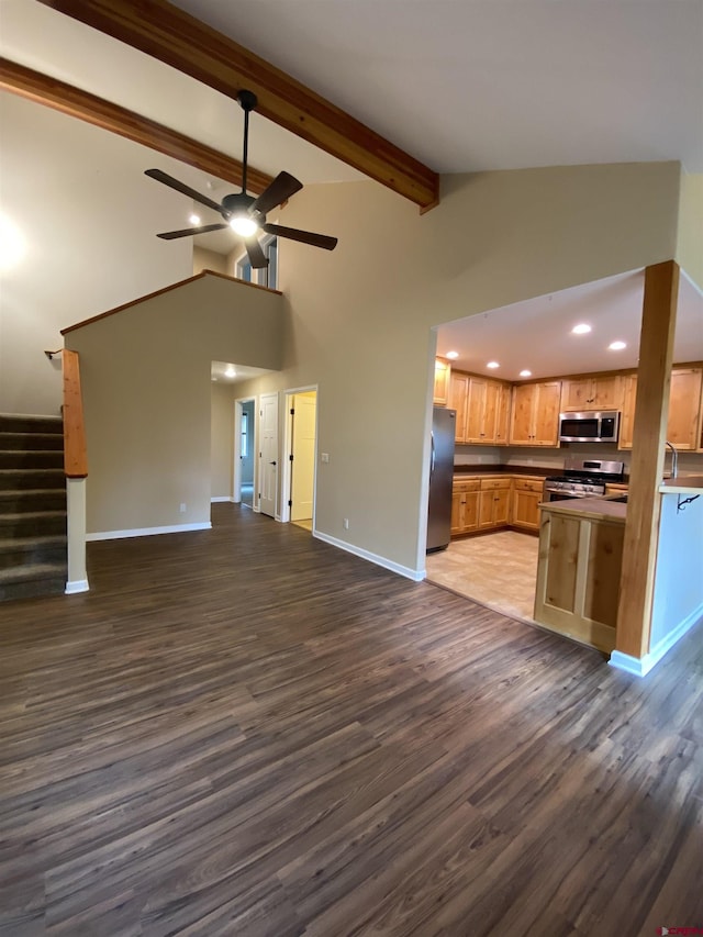 kitchen with light brown cabinets, ceiling fan, dark hardwood / wood-style floors, beam ceiling, and stainless steel appliances