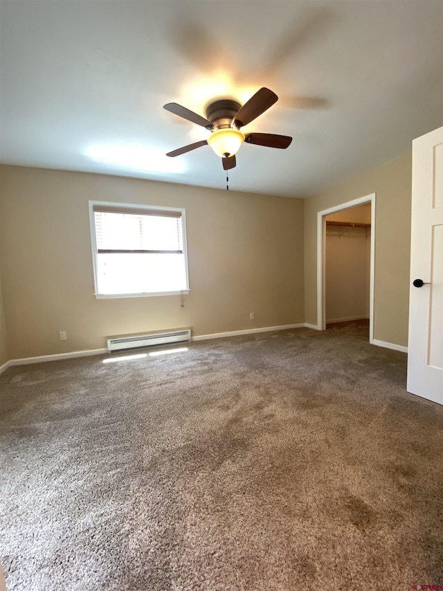 unfurnished room with dark carpet, baseboard heating, and ceiling fan