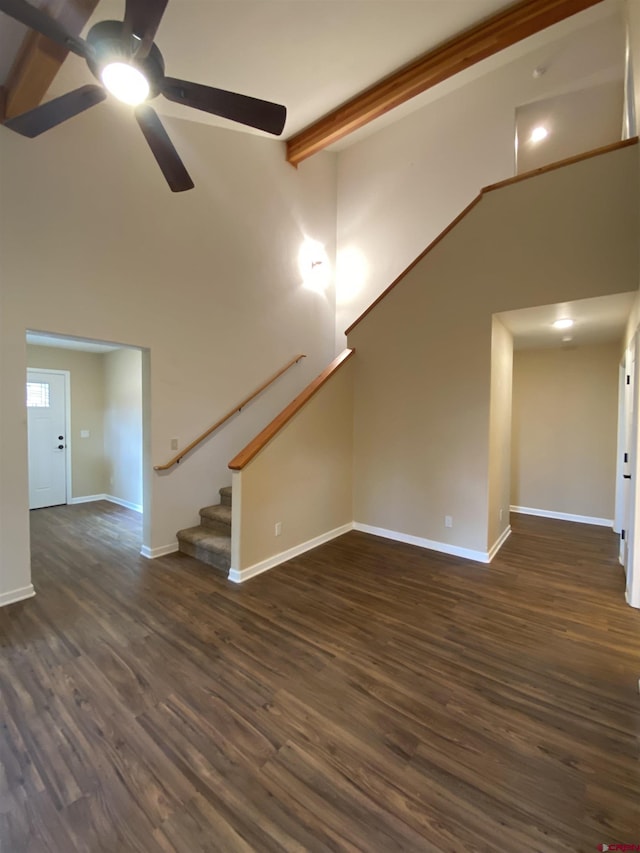 unfurnished living room featuring beam ceiling, ceiling fan, high vaulted ceiling, and dark wood-type flooring