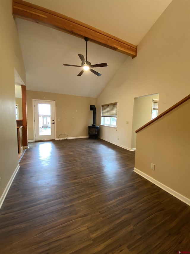 unfurnished living room with a wood stove, dark wood-type flooring, high vaulted ceiling, ceiling fan, and beam ceiling