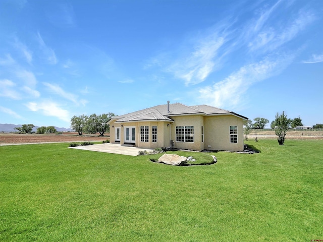 rear view of property with a lawn and a patio area