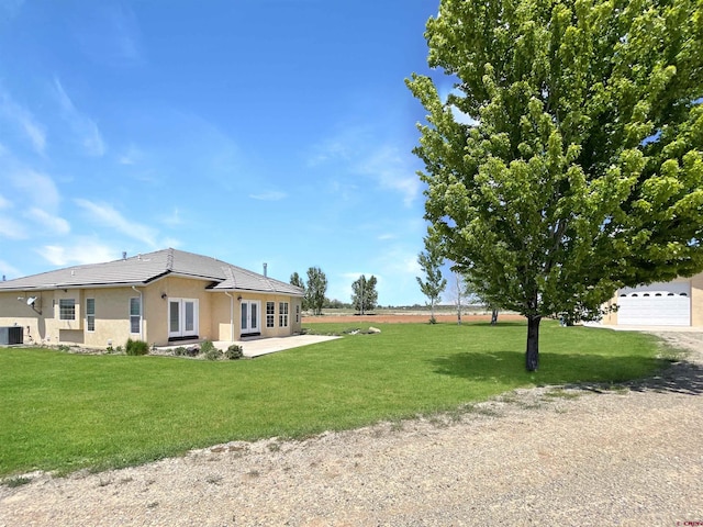 view of yard with french doors and a garage