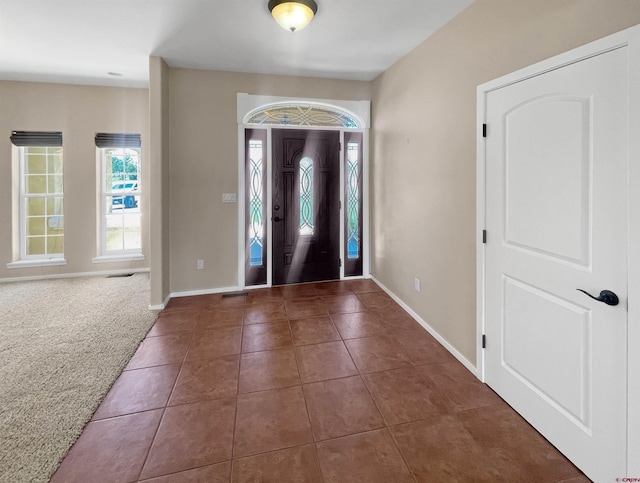 entrance foyer featuring dark carpet